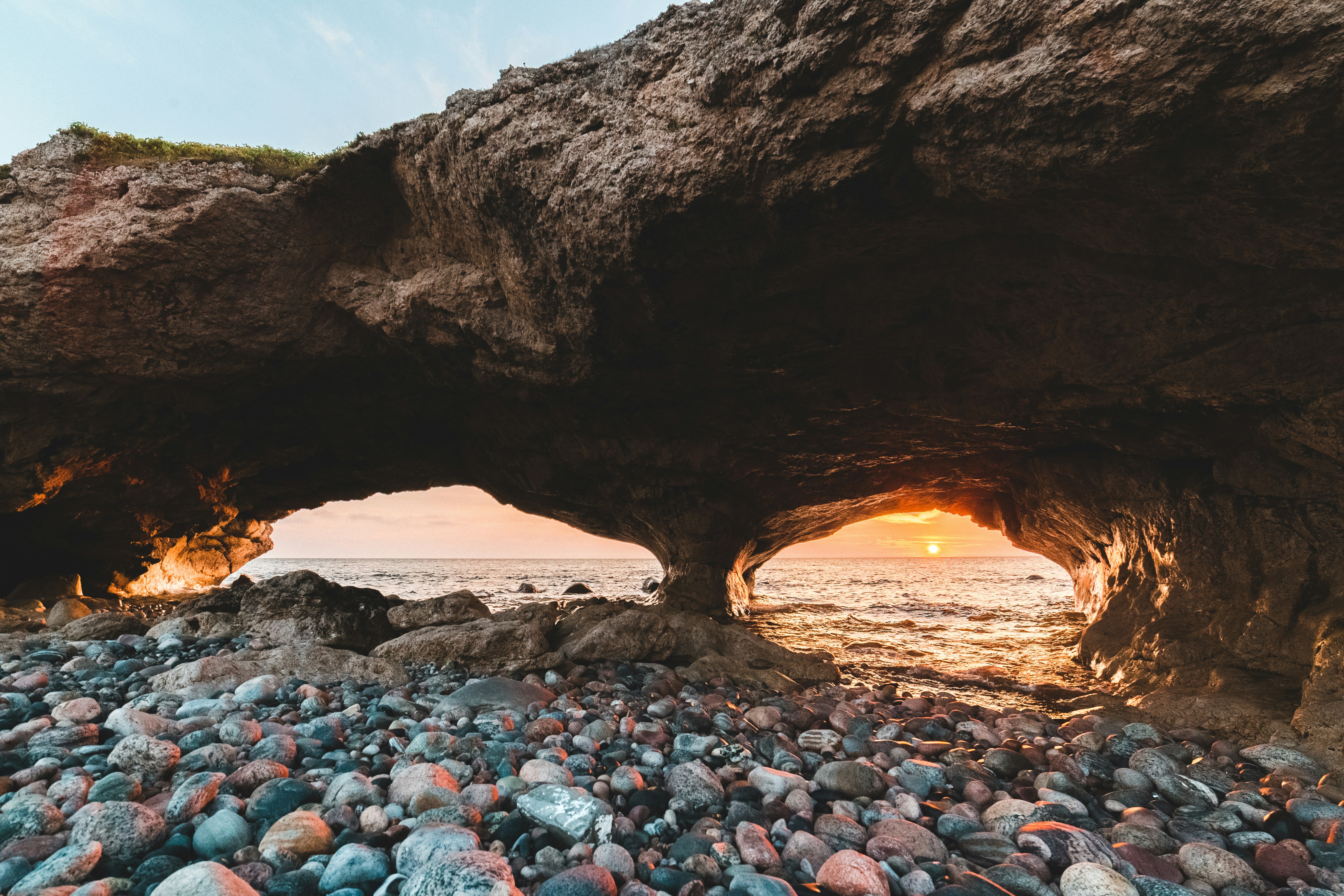 brown cave with gray rocks during sunset